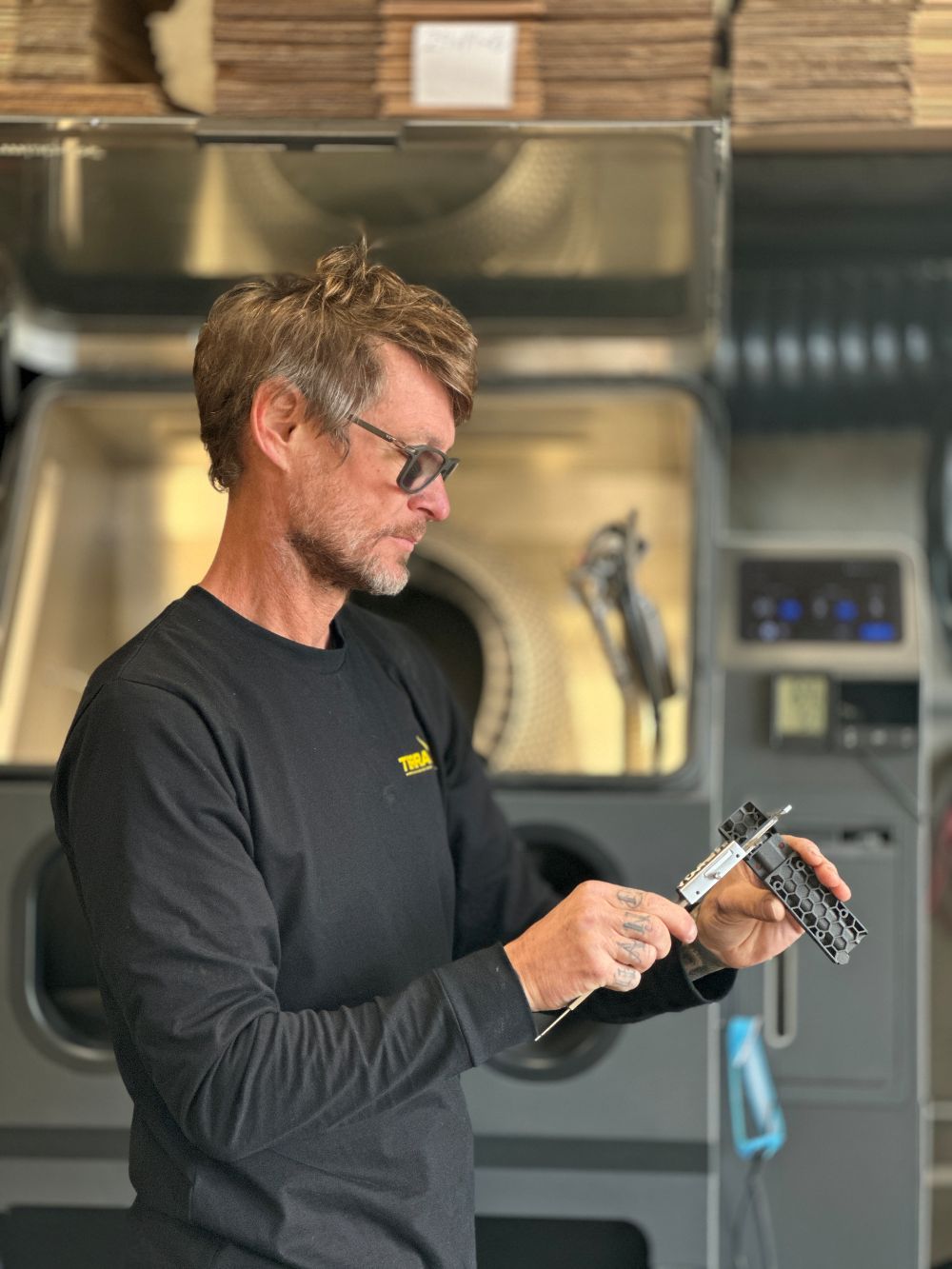Alex taking precise measurements while designing a custom heavy-duty vehicle mount in the Terra X workshop.