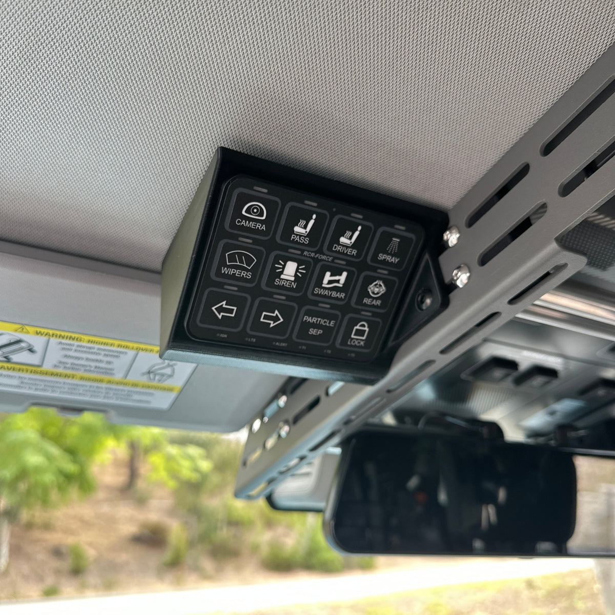 Front view of the Cabdok Switch-Pros Mount with a Switch-Pros 12 switch panel installed, mounted to the side of the Cabdok in an Ineos Grenadier