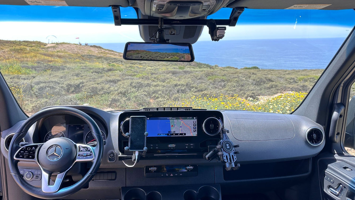 Car interior with dashboard view, steering wheel, and windshield showing our terra x dash and visor mounts. 