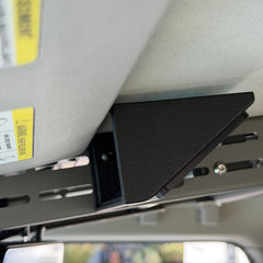 Black Nylon 12 Cabdok Switch-Pros Mount on the driver's side of the Cabdok in an Ineos Grenadier, seen from below next to the sun visor