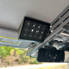 Front view of the Cabdok Switch-Pros Mount with a Switch-Pros 12 switch panel installed, mounted to the side of the Cabdok in an Ineos Grenadier