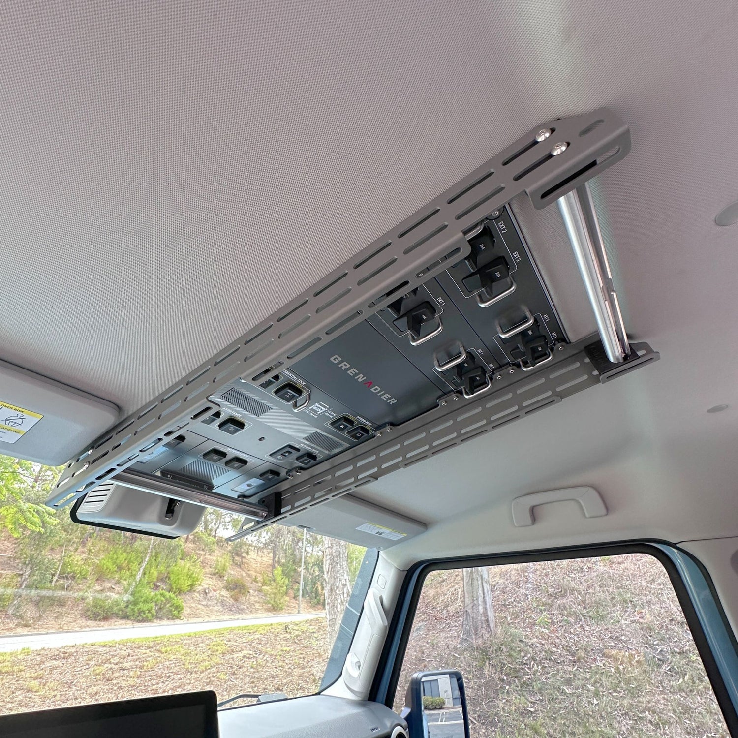 Cabdok overhead storage mount installed in Ineos Grenadier, tube tracks with hanging mounts above windshield