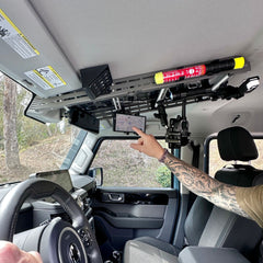 Hand adjusting phone mounted on Cabdok overhead storage mount in Ineos Grenadier